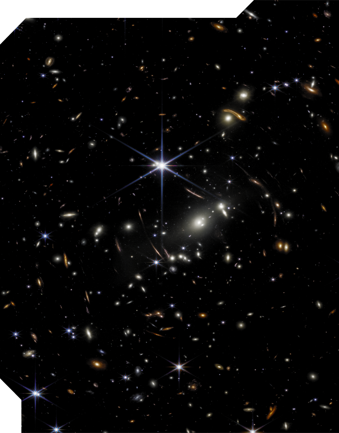 Fotografia de estrelas vistas no espaço. Há vários pontos brilhantes com cores azuladas, amareladas e alaranjadas. Há uma estrela azulada maior, com 6 pontas.
