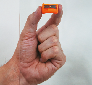 Fotografia de um vidro transparente, na qual atrás dele, há uma mão segurando um apontador.