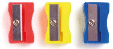 Fotografia de três apontadores de lápis, um ao lado do outro e com cores diferentes. Da esquerda para a direita temos: vermelho, amarelo e azul.