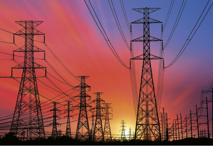 Fotografia de várias torres de transmissão de energia elétrica. Bem ao fundo está o sol se pondo em meio ao céu preenchido por cores em tons de rosa, laranja e azul.