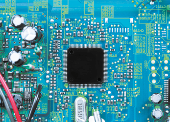 Fotografia de uma placa eletrônica, composta por uma placa rígida com tons azul e verde, com fios e chips.