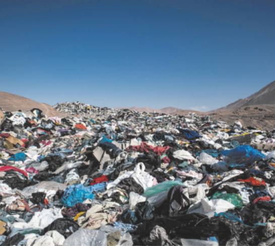 Foto de muitas roupas empilhadas em um local aberto.