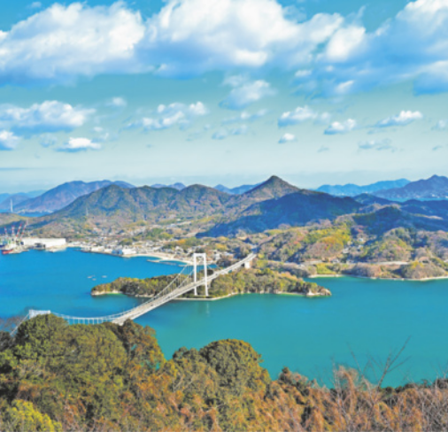 Foto de uma ilha, composta por montanhas altas e que se conecta com outras ilhas por meio de pontes.