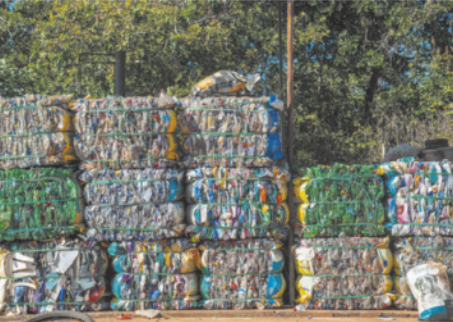 Foto de muitos objetos plásticos compactados. Esse lixo adquire a forma de grandes cubos.