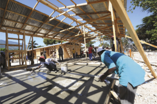 Foto de pessoas instalando as estruturas de madeira para uma construção.