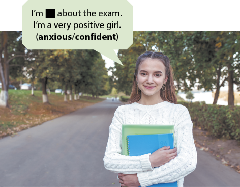 Fotografia de uma jovem ao ar livre em um caminho arborizado, sorrindo e segurando cadernos e livros nos braços. Há um balão de fala que diz em inglês: I'm lacuna para resposta about the exam. I'm a very positive girl. (anxious ou confident).