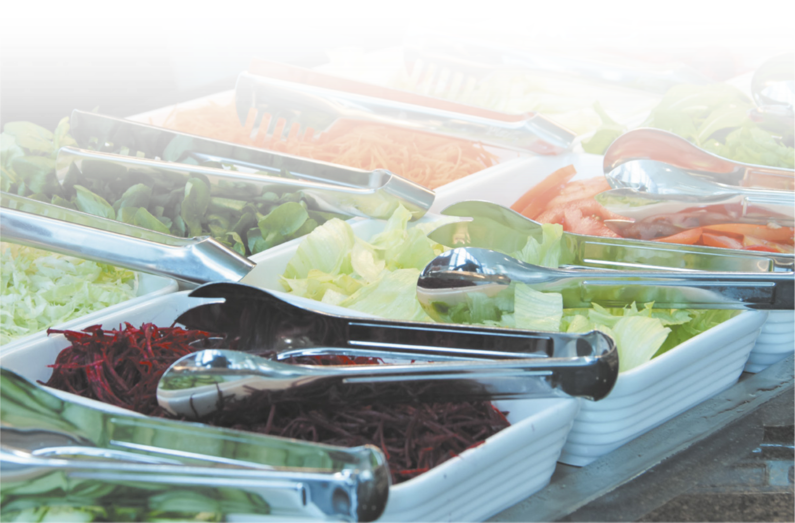 Fotografia de um buffet com saladas variadas, incluindo beterraba, alface, tomate, cenoura, entre outros.