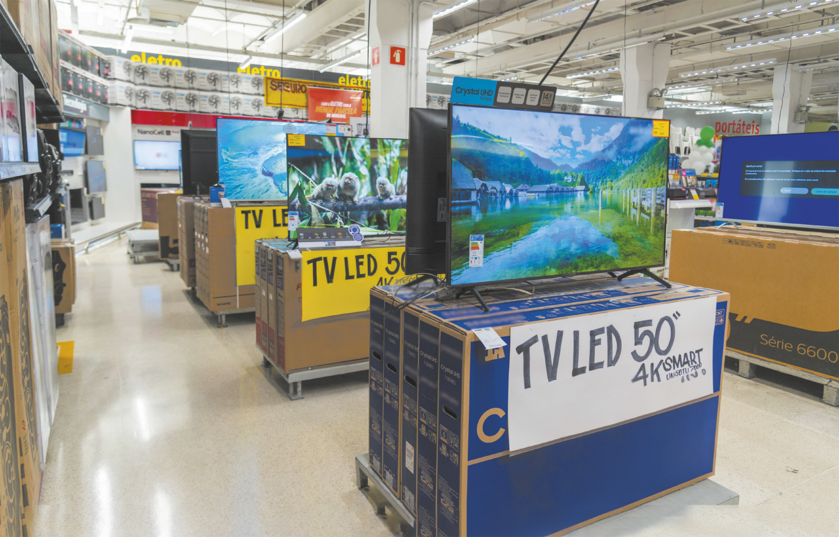 Fotografia de televisores LED de 50 polegadas expostos na seção de eletrônicos de uma loja.