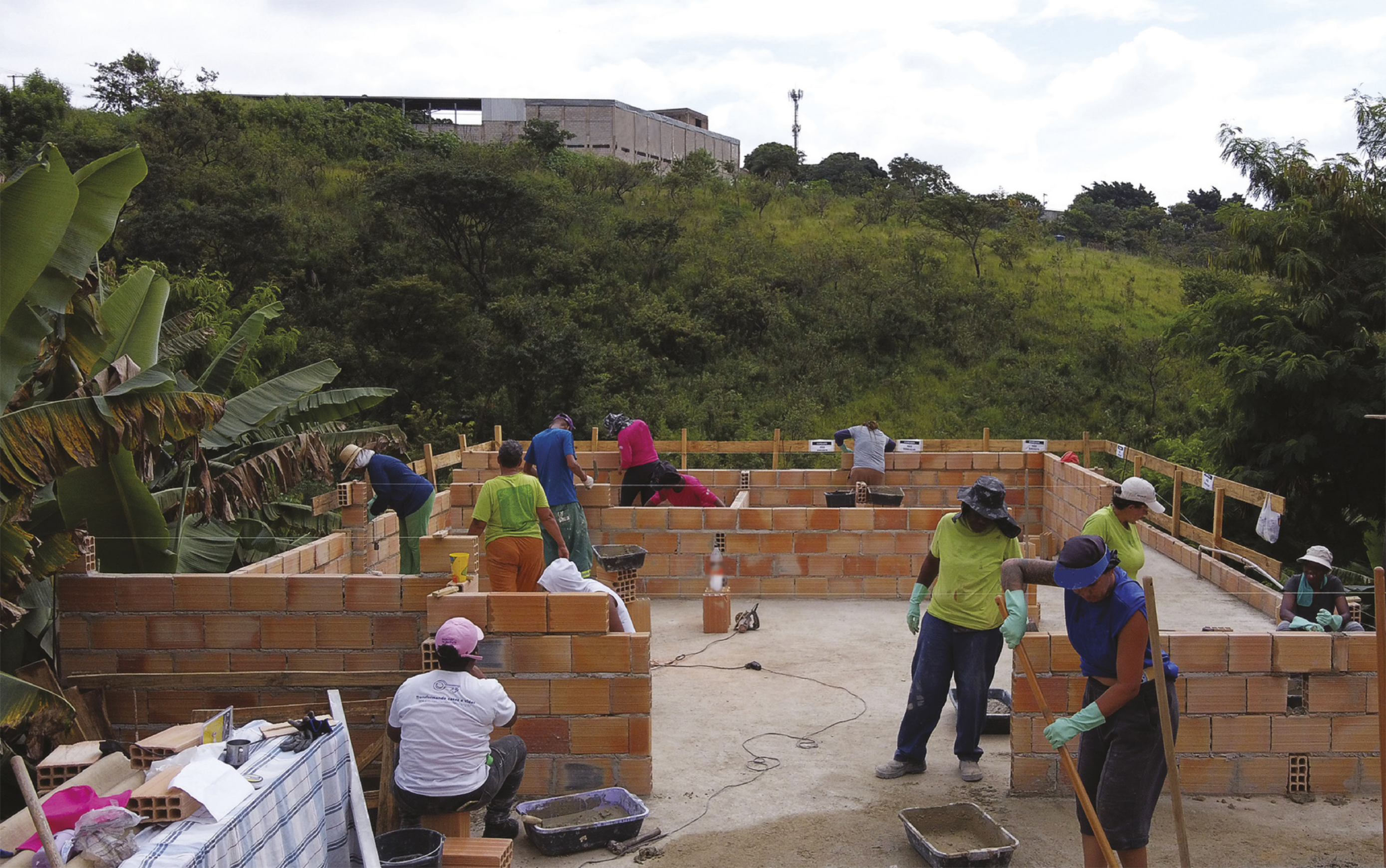 Fotografia de pessoas construindo uma casa.