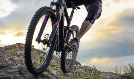 Fotografia de pessoa em uma bicicleta com pneus robustos e muito texturizado.