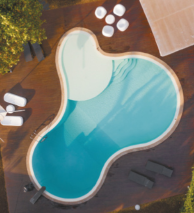 Fotografia com vista de cima de uma piscina de formato irregular, com bordas arredondadas.