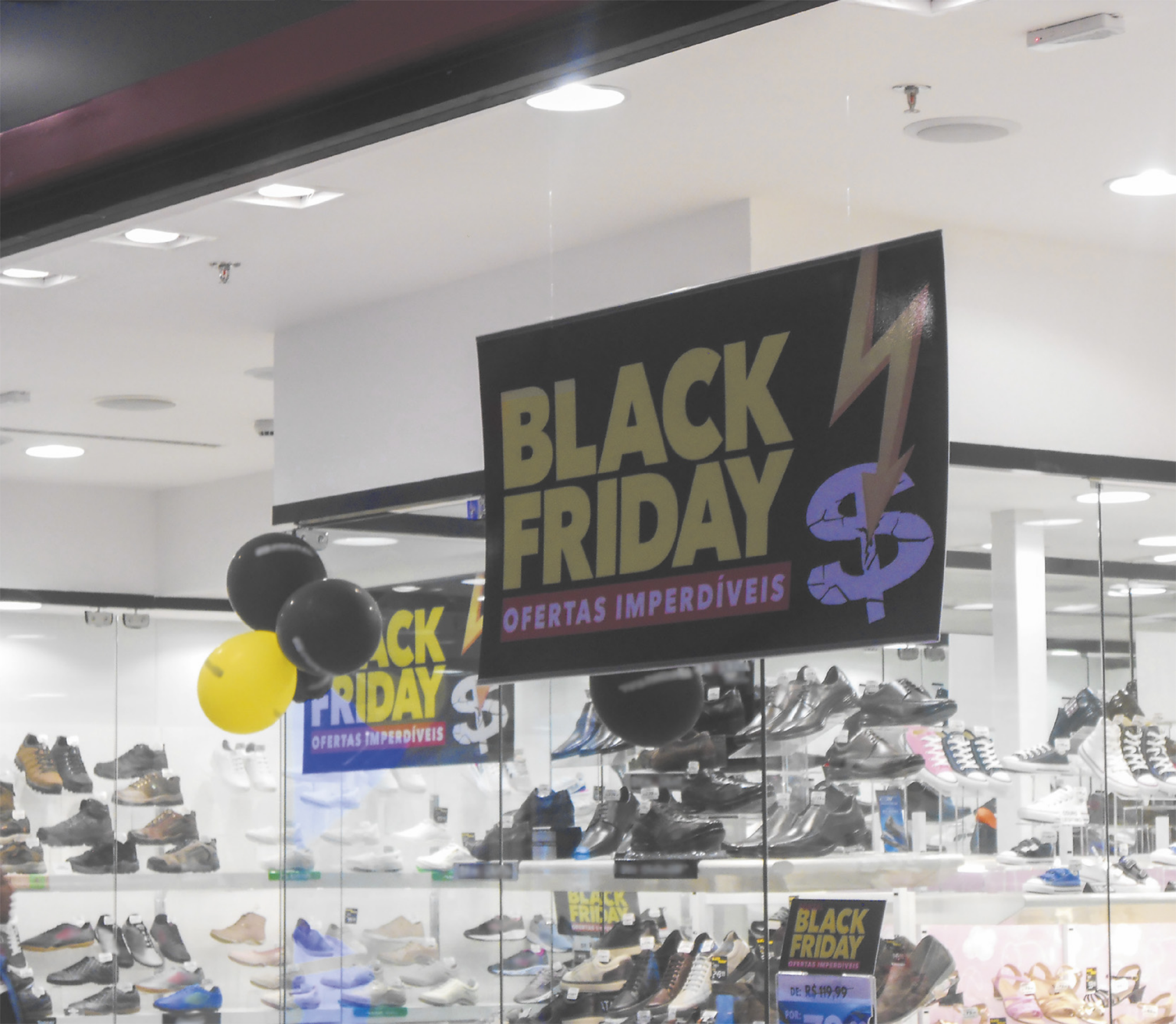 Fotografia de cartazes de Black Friday expostos nas vitrines de uma loja de sapatos.