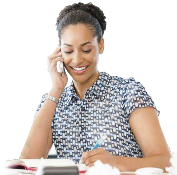 Fotografia de uma mulher sorrindo, sentada, falando ao telefone e, com a outra mão, escrevendo em um caderno.