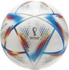 Fotografia de uma bola de futebol. Ela é de cor branca e possui quadriláteros se unindo ao longo da superfície. Os lados dos quadriláteros são coloridos em azul, vermelho e amarelo.