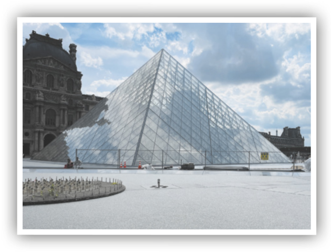 Fotografia do museu do Louvre. Ele possui formato de uma pirâmide. As faces são triângulos de vidro.