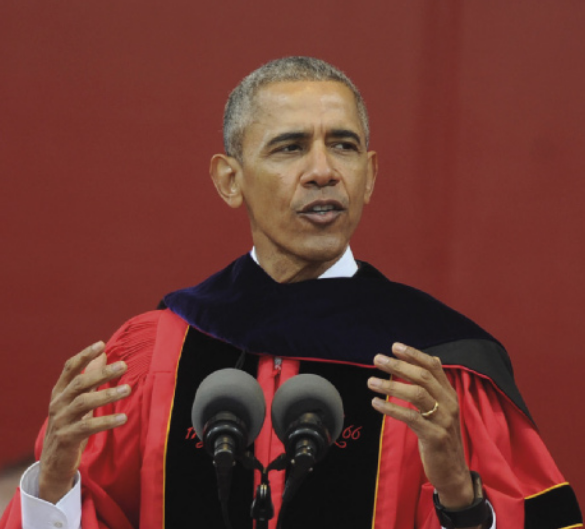 Foto de Barack Obama discursando. Ele é um homem negro, de cabelos grisalhos e uma beca.
