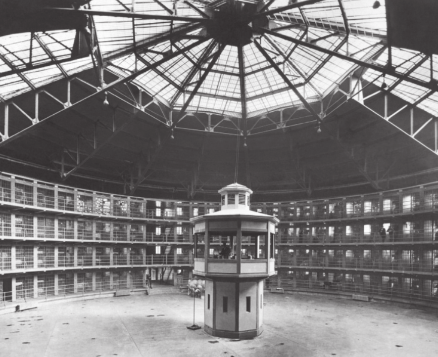 Imagem de torre no centro de uma prisão circular. As celas são distribuídas ao longo de quatro pavimentos e a torre contém janelas voltadas para todos os lados da prisão.