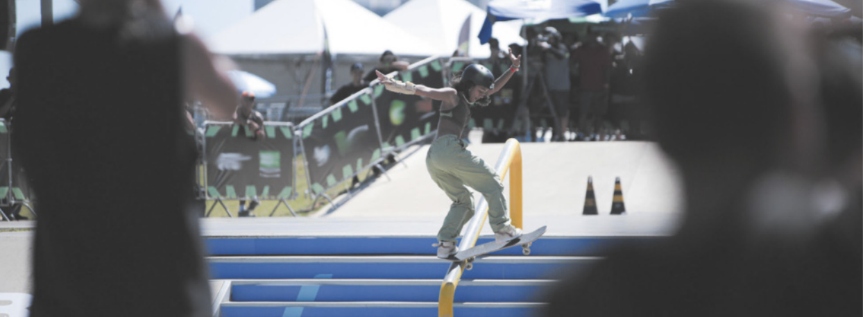 Fotografia de Rayssa Leal deslizando com um skate sobre o corrimão de uma escada.