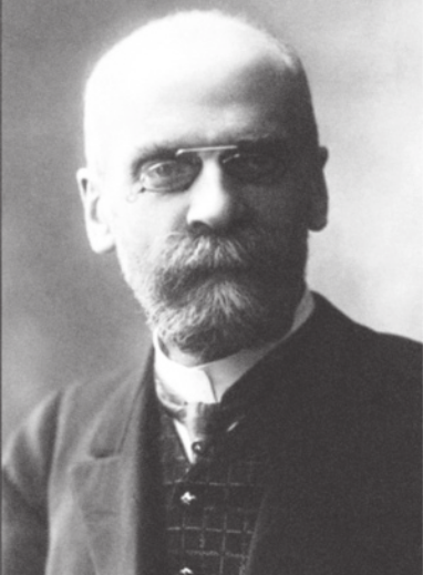 Fotografia em preto e branco de Émile Durkheim. Ele é branco, careca, possui cavanhaque e usa colete e paletó.