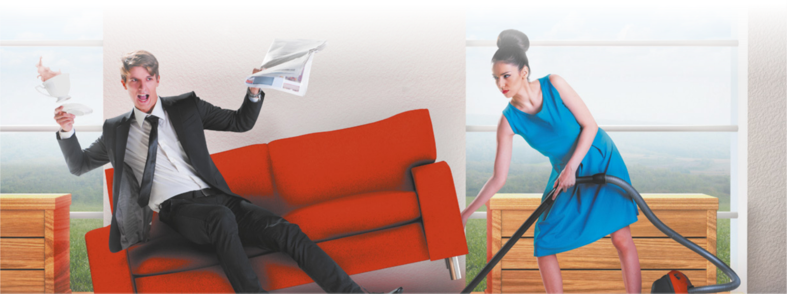 Imagem de homem e mulher em uma sala de estar. Com expressão zangada, a mulher, à direita, passa aspirador de pó embaixo de um sofá, erguendo-o com a mão direita. O homem está sentado no sofá, segurando um jornal e uma xícara, que cai no momento em que a mulher levanta o sofá.