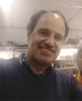 Fotografia de Amaury César Moraes sorrindo. Ele é branco, calvo e usa camisa polo.