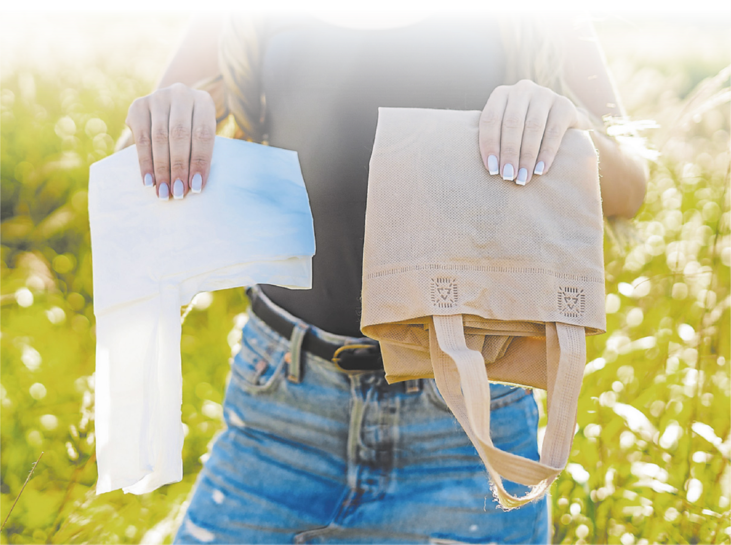 Fotografia de uma pessoa segurando uma sacola de pano do estilo 'ecobag' e uma sacola plástica.