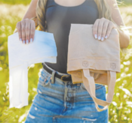 Fotografia de uma pessoa segurando uma sacola de pano do estilo 'ecobag' e uma sacola plástica.