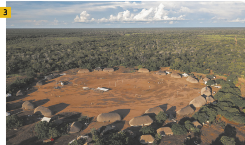 Fotografia 3 apresenta uma aldeia indígena vista de cima, rodeada por floresta. As moradias, organizadas em formato circular, possuem coberturas arredondadas construídas com materiais naturais. No centro da aldeia, há uma ampla área aberta, sem edificações. Ao fundo, observa-se a imensidão da floresta que se estende até o horizonte.