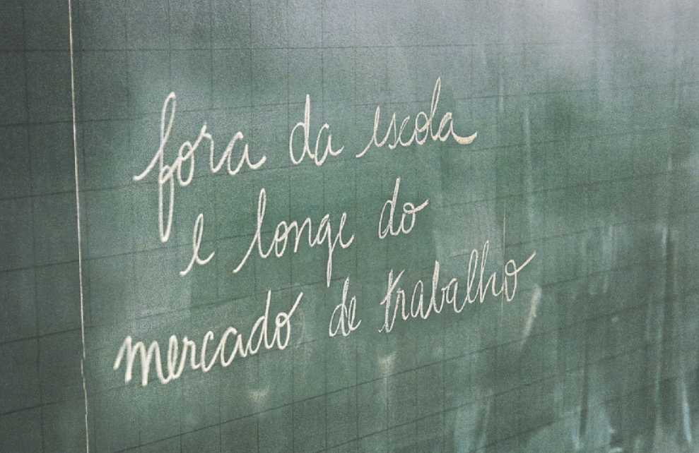 Fotografia de uma lousa escrito a giz 'Fora da escola e longe do mercado de trabalho'.
