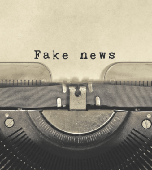 Imagem de uma máquina de escrever com uma folha, escrito 'Fake News'.