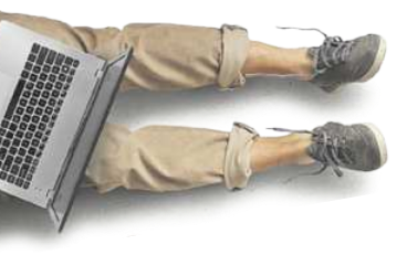 Imagem da perna de uma pessoa sentada ao chão, segurando um notebook.