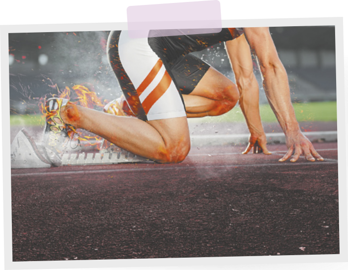 Imagem de um atleta de corrida em posição de partida em uma pista. Ele está agachado, com um joelho apoiado no chão e o outro flexionado, com as mãos posicionadas à sua frente, também apoiadas no chão.