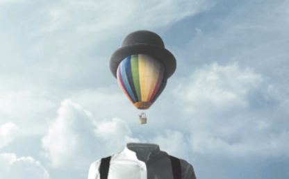 Imagem de um corpo humano vestindo uma camisa social, com a cabeça representada por um balão que flutua no céu e usa um chapéu. Ao fundo, vê-se um céu com nuvens.