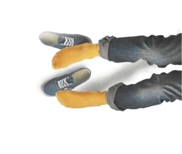 Imagem das pernas de uma pessoa sentada no chão, flexionadas, usando meias amarelas com o tênis ao lado.
