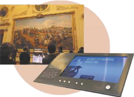 Imagem de pessoas em um museu observando um grande quadro exposto. No destaque, há uma tela digital com informações sobre a exposição.