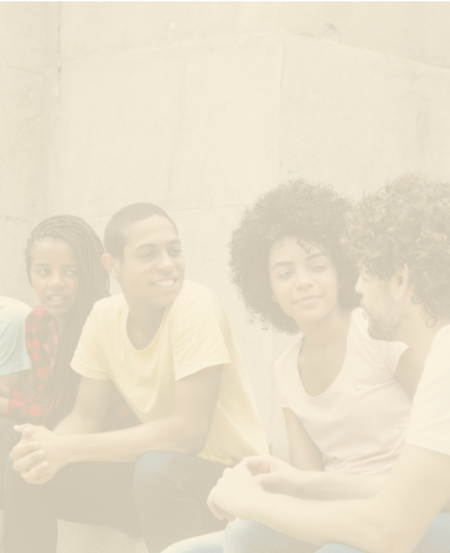 Fotografia desfocada de quatro jovens sentados, dois homens e duas mulheres, conversando de forma descontraída.