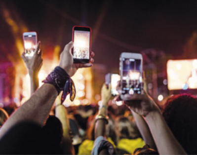 Foto de pessoas usando o celular para filmar um show.