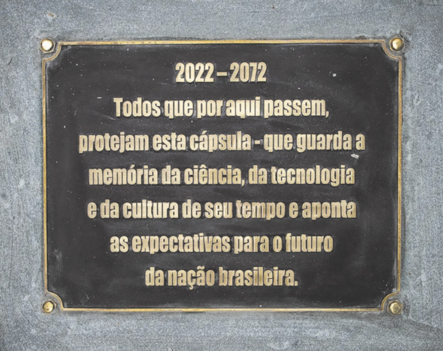 Placa com a seguintes informações: '2022 a 2072. Todos que por aqui passarem, protejam esta cápsula - que guarda a memória da ciência, da tecnologia e da cultura de seu tempo e aponta as expectativas para o futuro da nação brasileira'.