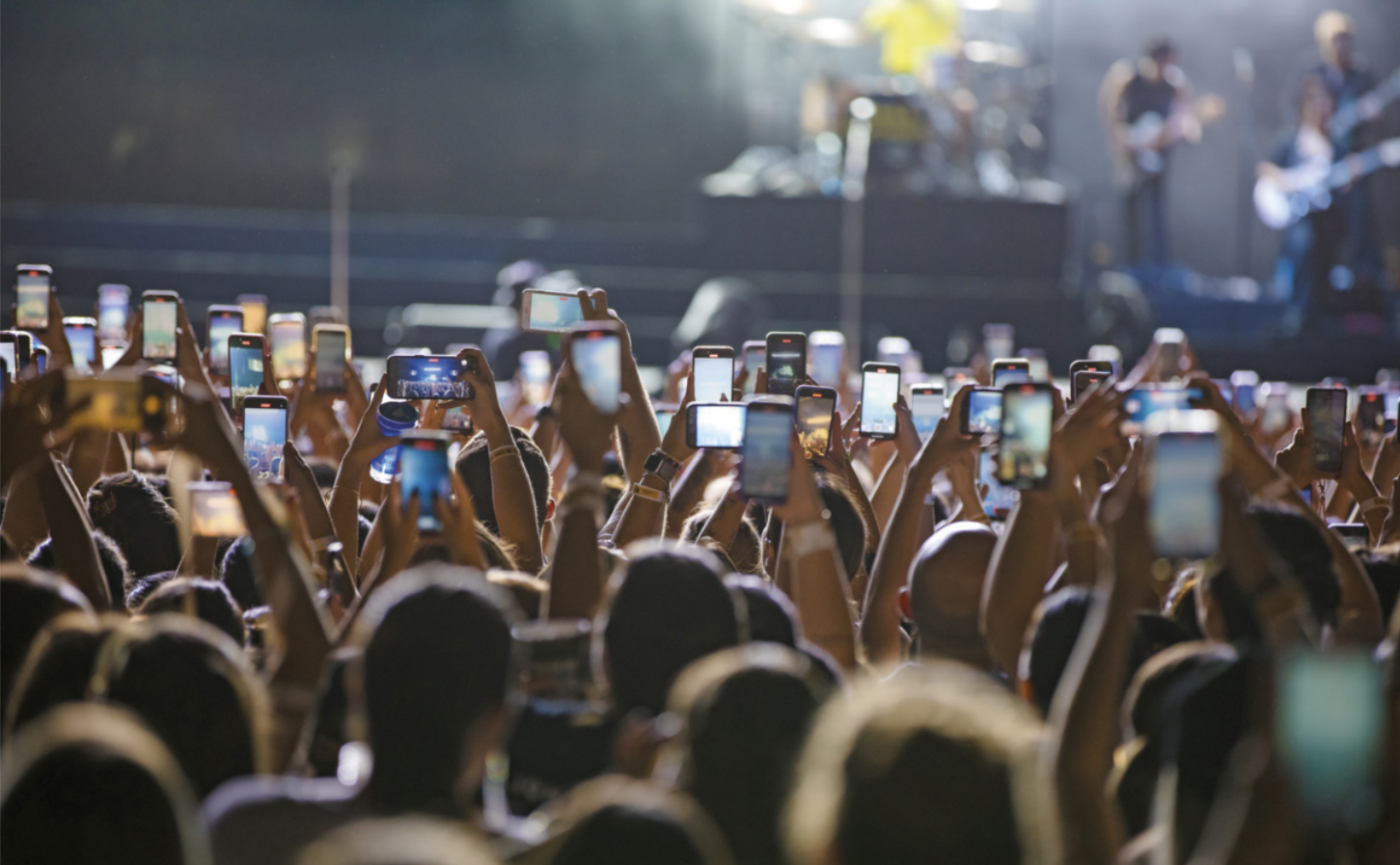 Foto de muitas pessoas usando o celular para filmar um show.