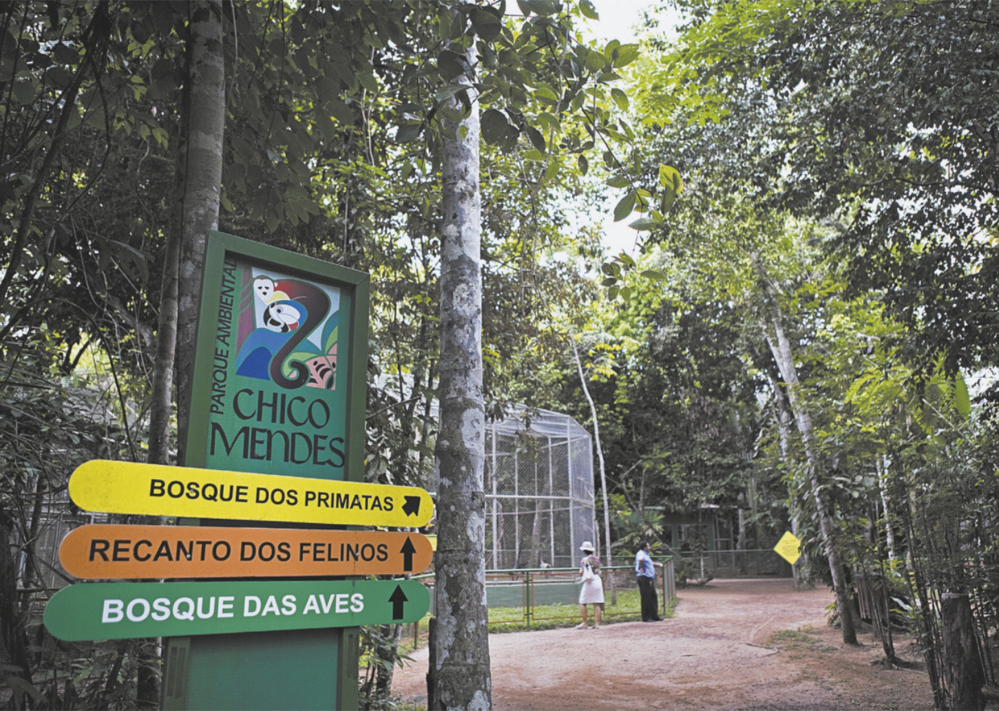 Foto de placas com as seguintes indicações: 'Parque Chico Mendes. Bosque dos primatas. Recanto dos felinos. Bosque das aves'.